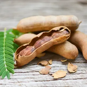 FlexBoost Fruit - Opened FlexBoost Fruit with seeds and shell fragments on a wooden surface, symbolizing flexibility-enhancing properties.